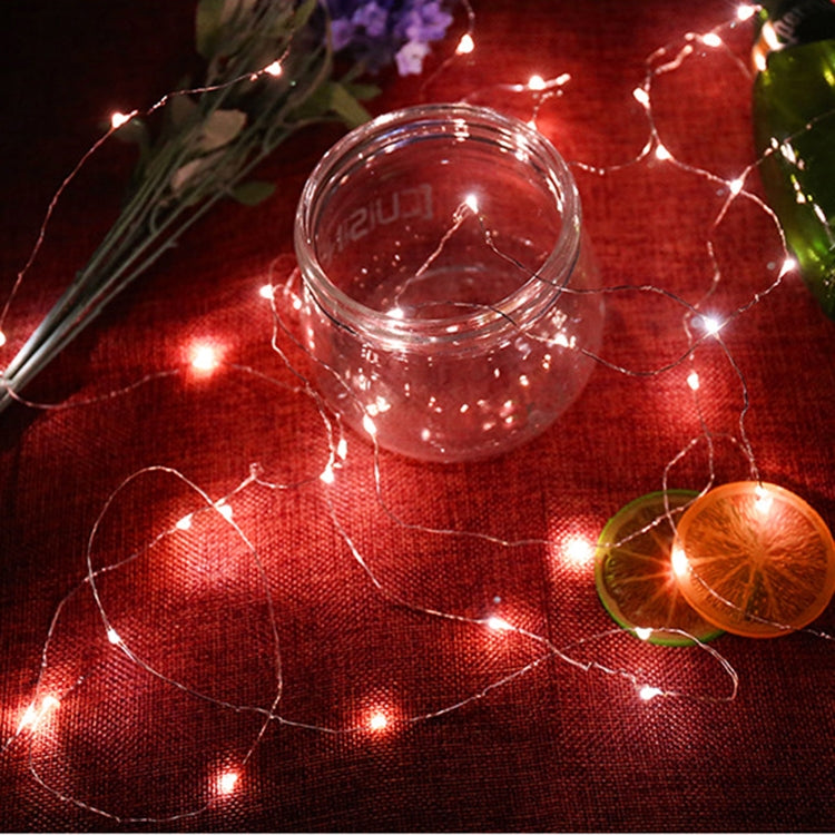 Red LED fairy string lights wrapped around glass bottles and jars, glowing wire strands