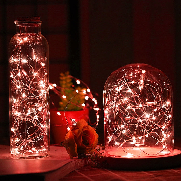 Warm red LED fairy lights in glass bottles and dome jar, glowing wire strands