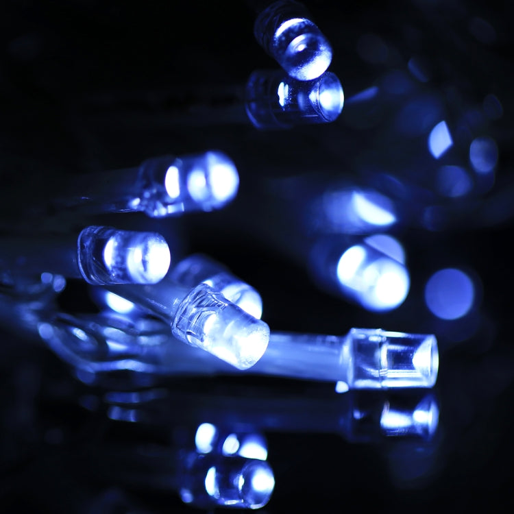 LED curtain light bulbs glowing blue on clear wire strand.