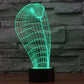 Cobra-style wire grid desk lamp glowing green on a black cylindrical base