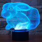 Blue glowing rabbit-shaped night light desk lamp on a black base