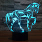 Geometric horse-shaped LED desk lamp with cyan blue glow on a black base.