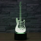 Guitar-shaped LED night light with black base, white guitar with green glow