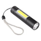 Black flashlight with lanyard and front lens, side view of the LED window