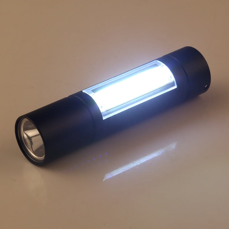 Black flashlight shining a bright white beam from the front lens