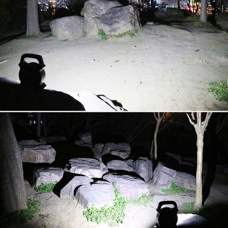 Handheld camping lamp shining on rocks and ground at night