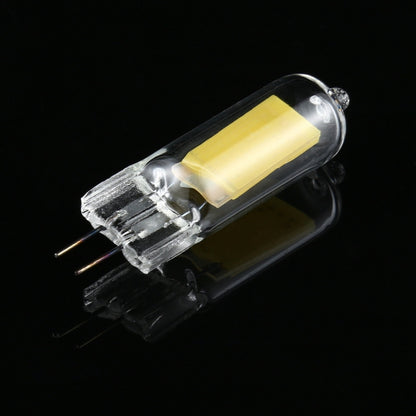 Glass LED bulb with clear capsule, two metal pins, and a yellow internal LED chip