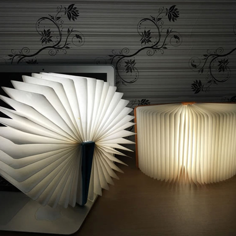 White glowing foldable fan night light with ribbed panels and central LED