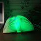 Green glowing foldable fan night light with ribbed panels and central LED