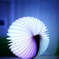 White-blue folding semicircle night light, softly glowing