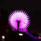 Purple-pink folding semicircle night light glowing, held by hand
