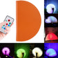 Brown semicircle night light with remote, displaying multicolor light modes