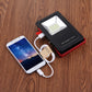 LED emergency light with USB cable charging a smartphone on a wood surface