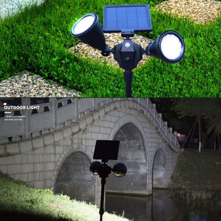 Dual-head solar LED spotlight stake with solar panel and two outward-facing lights.