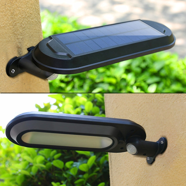 Black solar wall lamp with rectangular panel mounted on stucco