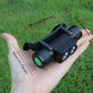 Compact black adjustable LED headlight in hand with dual front bulbs and head strap