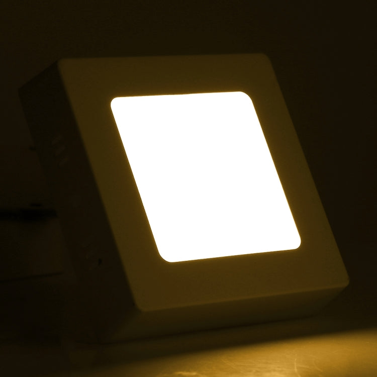 Warm white illuminated square LED panel light with glowing front diffuser