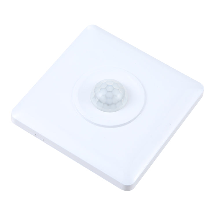 White motion sensor switch panel with circular detection lens, tilted view