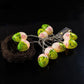 LED Easter egg string lights with green eggs on dark surface near straw nest