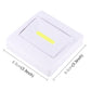 Angled view of square white night light lamp with yellow LED strip inside the clear window