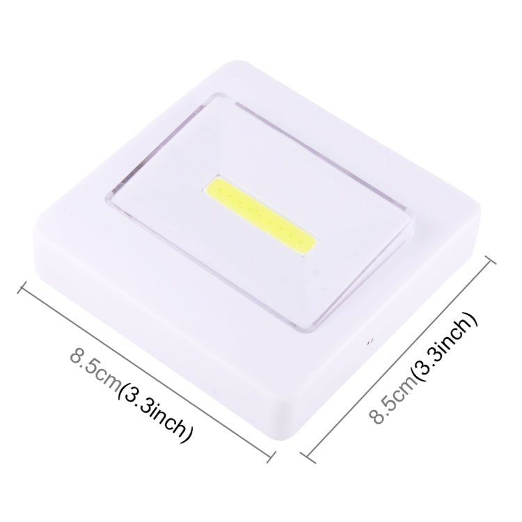 Angled view of square white night light lamp with yellow LED strip inside the clear window