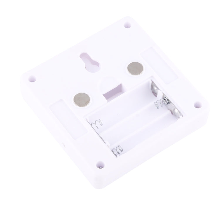 Underside of square white night light lamp with battery contacts and spring hardware