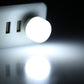 Mini USB night light glowing white, with silver USB plug visible behind.