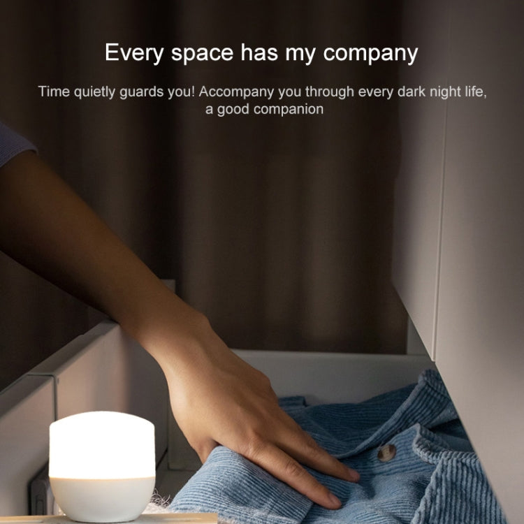 Mini USB night light on a bedside surface, emitting a soft white glow.