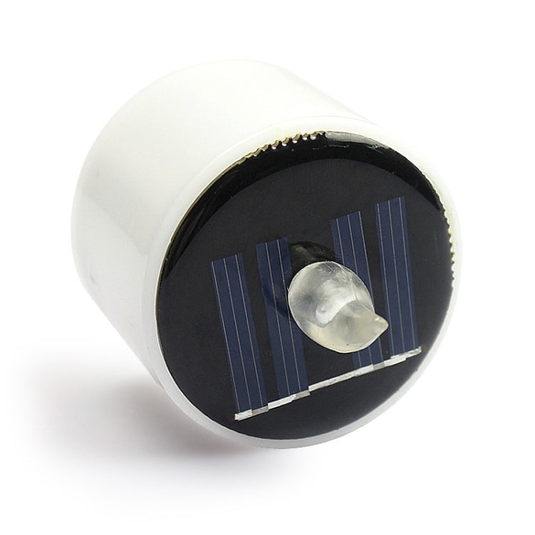 White cylindrical LED night light with dark solar panel and clear flame LED top