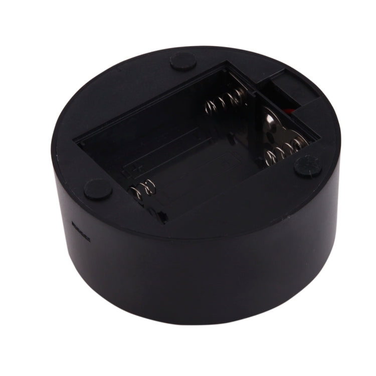 Black round lamp base with open battery compartment and metal contacts
