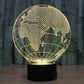Gold-lit globe desk lamp showing world map lines on a black base