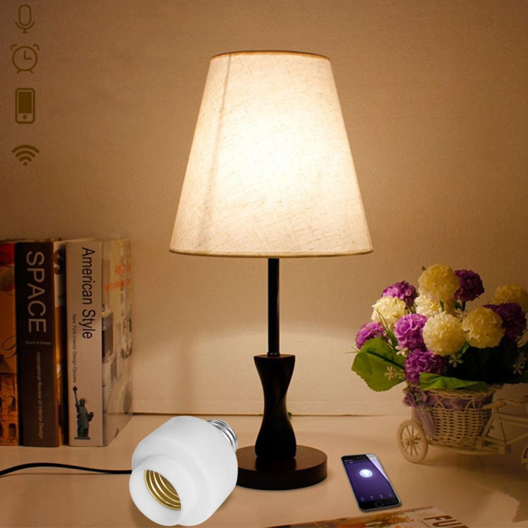 White E27 smart bulb socket adapter with silver screw threads next to lamp
