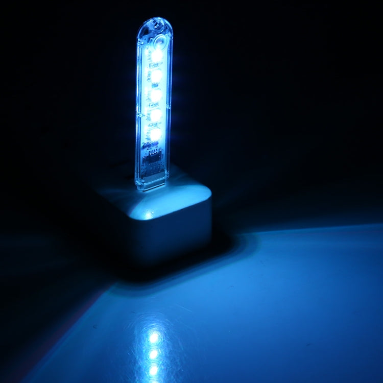Small blue LED night light with 5 glowing bulbs on a white base