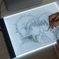 A4 USB LED tracing light box with illuminated white panel for sketching, pen in use