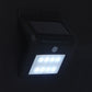 Black solar motion sensor wall light glowing with white LED dots