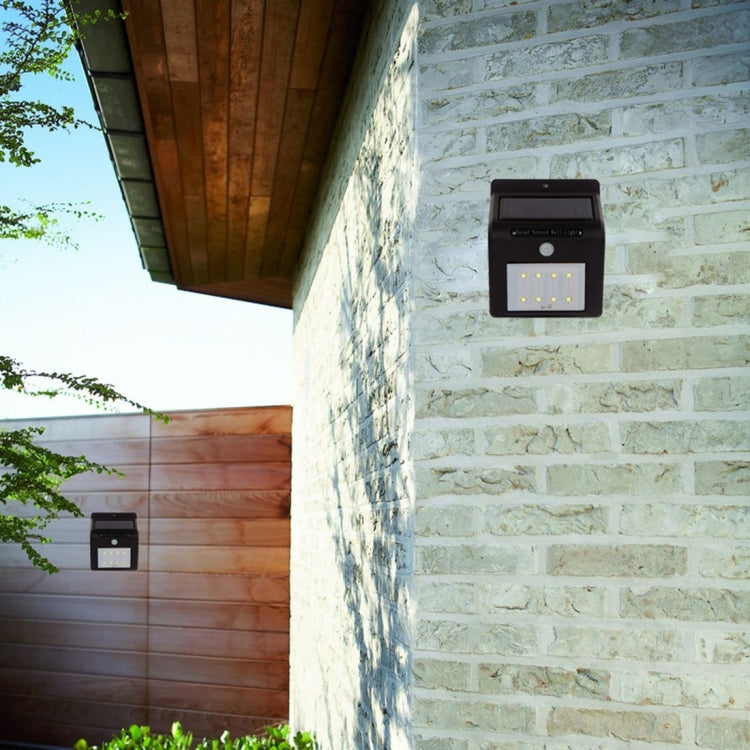Black solar motion sensor wall light mounted on light stone brick