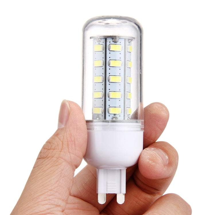 LED corn bulb held in hand with clear top lens and two-pin plug base