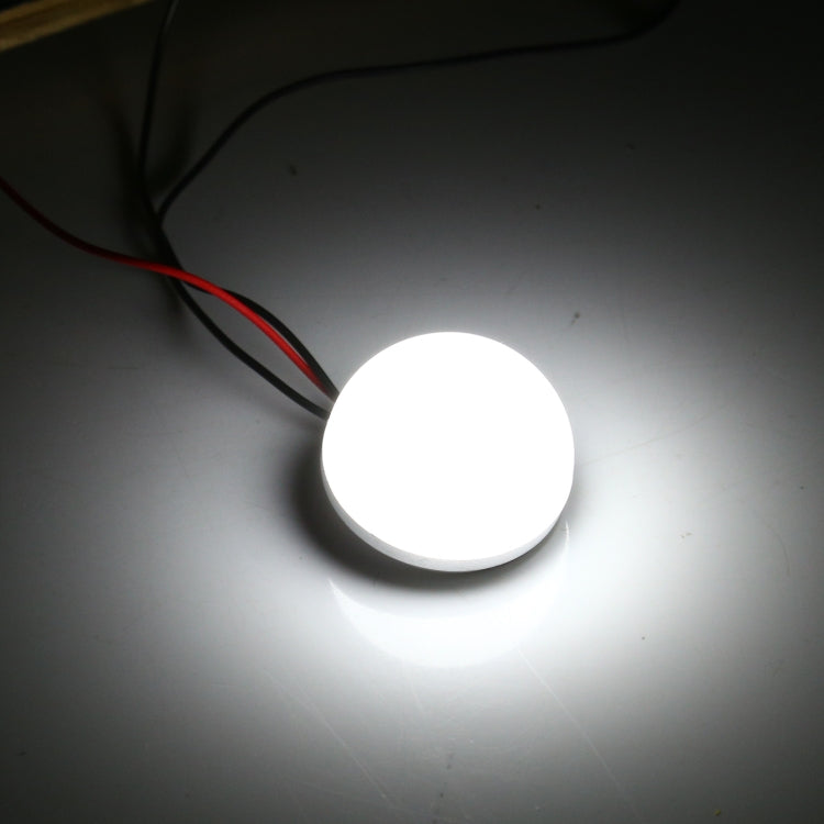Powered LED bulb glowing white, frosted dome cap, threaded base, red/black wires