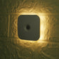 Wall-mounted square LED motion sensor light glowing warm white