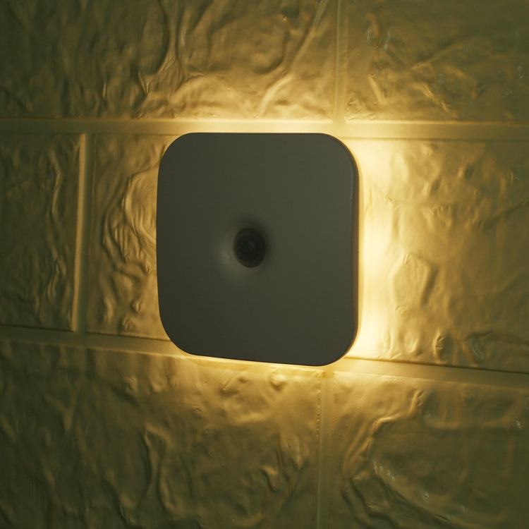 Wall-mounted square LED motion sensor light glowing warm white