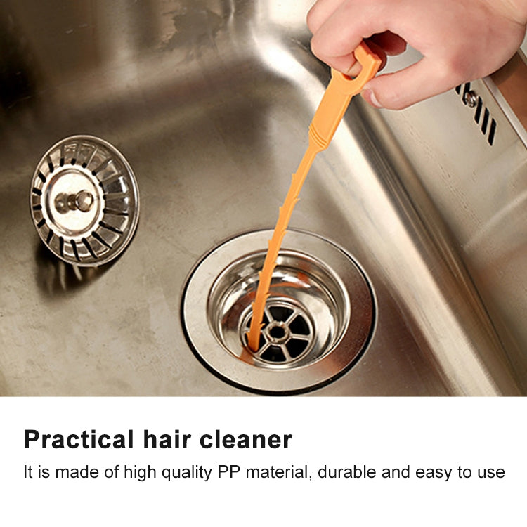 Orange drain hair cleaner hook in use, held above a sink drain