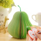 Green pear-shaped note sticker with accordion ridges and small writing inset