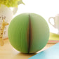 Green watermelon-shaped note sticker with folded accordion paper ridges