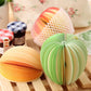 Group of accordion fruit note stickers in orange, yellow, and green on wooden stands