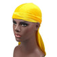 Bright yellow velvet turban cap with wrapped band and long trailing side tail