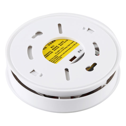 Underside of white smoke and heat detector with mounting slots and yellow label