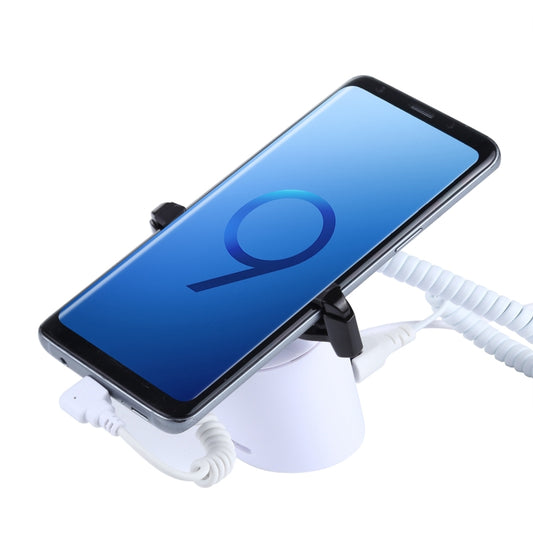 White cylindrical phone security display stand with black clamps and coiled charging cable