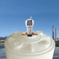 Solar ultrasonic liquid level meter transmitter mounted on a white water tank