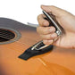 Black guitar capo in hand, spring clamp resting on guitar strings