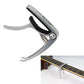 Silver zinc alloy guitar capo with black fret-pressing pad, on acoustic guitar